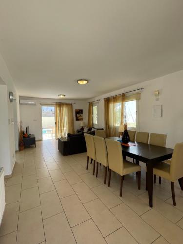 a dining room and living room with a table and chairs at Casa Pernera in Protaras