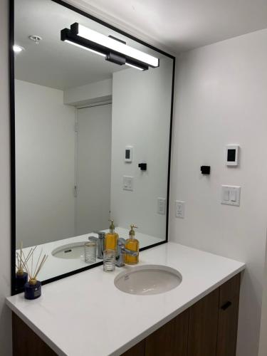 a bathroom with a sink and a large mirror at Victoria private studio suite in Victoria