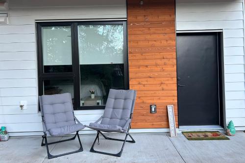 two chairs sitting on a porch in front of a house at Victoria private studio suite in Victoria