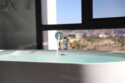 un lavandino con acqua che esce da una finestra di AYLOL-أيلول a Qurayyah