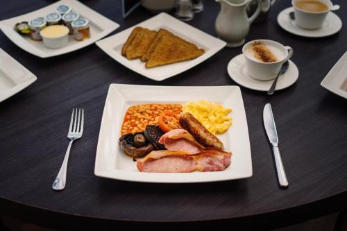 a table with a plate of breakfast food on it at The Angel Hotel in Leamington Spa