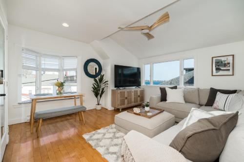 格洛斯特CbytheSea - Ocean View Penthouse的客厅里有一张沙发和一台电视