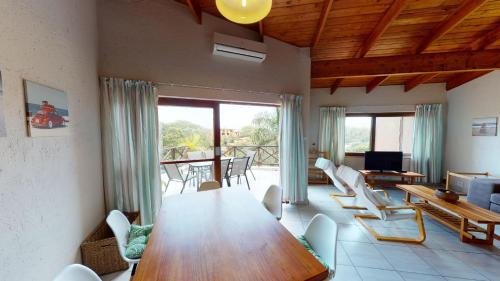 a living room with a wooden table and chairs at San Lameer Villa 1931 by Top Destinations Rentals in Southbroom