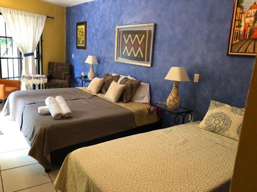 um quarto com 2 camas e uma parede azul em Suite Antequera en mexico em Oaxaca de Juárez