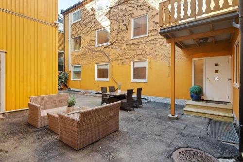 a patio with furniture and a yellow building at Flott leilighet MIDT i Tønsberg! in Tønsberg