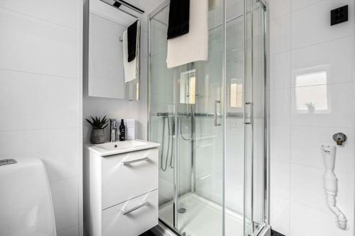 a white bathroom with a shower and a toilet at Flott leilighet MIDT i Tønsberg! in Tønsberg