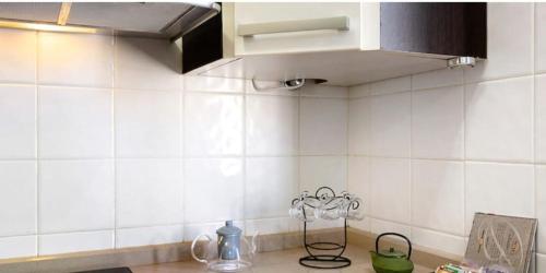 a kitchen with white tile walls and a sink at Residencial Maresia el Medano in El Médano
