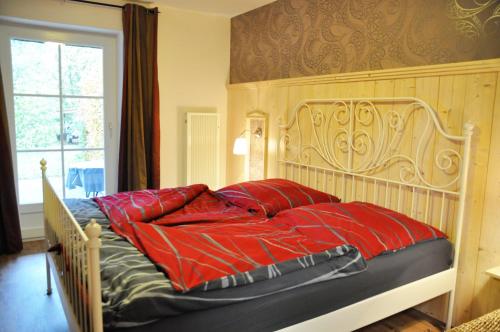 1 cama con almohadas rojas en el dormitorio en Petersdorf Ferienwohnung Kleine Auszeit, en Westfehmarn