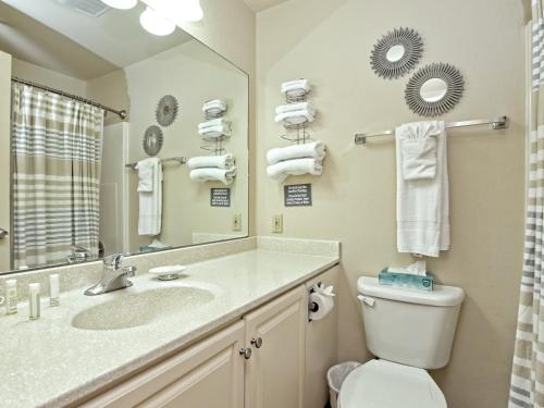 y baño con lavabo, aseo y espejo. en Waterfront Bungalow With Pool & Hot Tub #11, en Lakeway