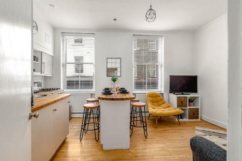 a kitchen with a counter and stools in a room at Cozy Covent Garden/Oxford Street apartment in London