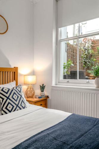 a bedroom with a bed and a window at Cozy Covent Garden/Oxford Street apartment in London
