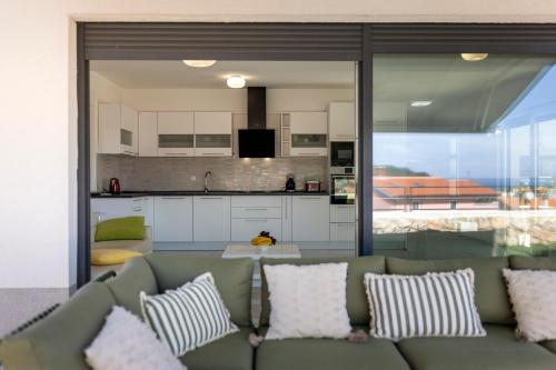 a living room with a couch and a kitchen at Apartments Olea in Mali Lošinj