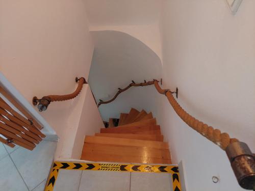 a staircase in a house with a wooden stair case at Patak Üdülőház (Ferienhaus) in Nagyvisnyó