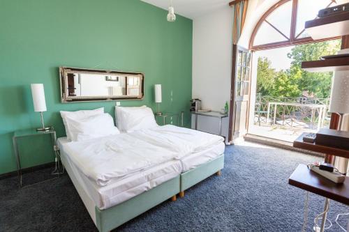 a bedroom with a bed and a large window at MÖRWALD Grafenegg Hotel in Grafenegg