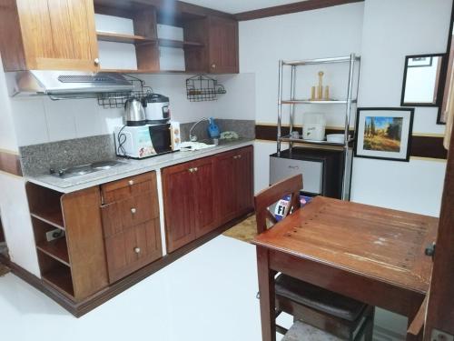 a kitchen with wooden cabinets and a table in it at Isabelle Garden Villas 828 in Manila