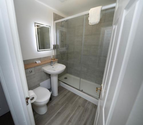 a bathroom with a toilet and a sink and a shower at The Angel Hotel in Leamington Spa