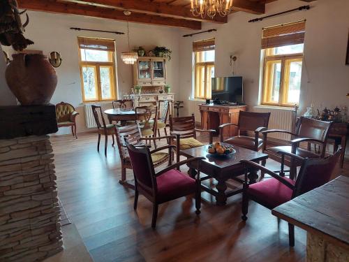 une salle à manger avec des tables et des chaises ainsi qu'une cuisine dans l'établissement Patak Üdülőház (Ferienhaus), à Nagyvisnyó