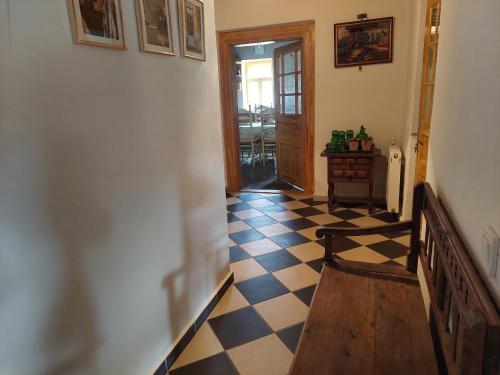 a hallway with a checkered floor and a wooden bench at Patak Üdülőház (Ferienhaus) in Nagyvisnyó