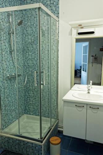 une salle de bain avec une douche en verre et un lavabo dans l'établissement Suite George 5 + parking prive et securise, à Arras