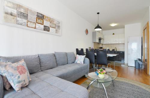 a living room with a gray couch and a table at Lungo Mare Apartment with Terrace in Pula