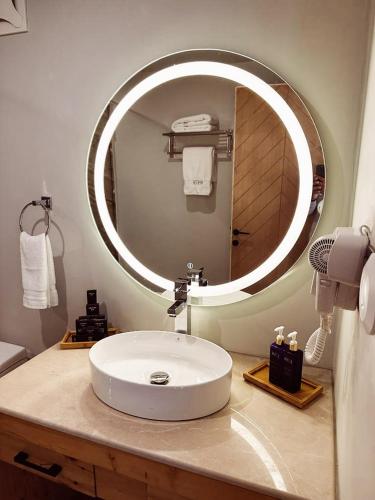 a bathroom with a sink and a large mirror at Khoj Resorts Shigar in Shigar