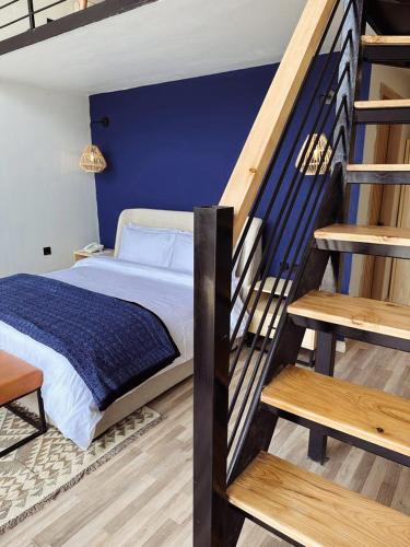 a bedroom with a bed and a blue wall at Khoj Resorts Shigar in Shigar