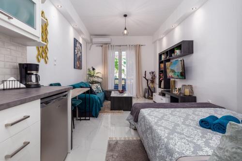 una camera da letto con due letti, una cucina e un divano di Casa di Rosi, Seaview studio in corfu town a Città di Corfù