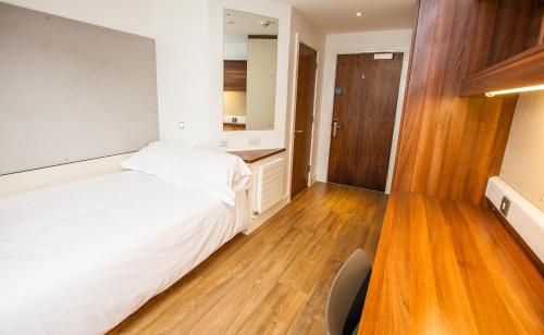 a bedroom with a white bed and a mirror at Willow Court in Stirling
