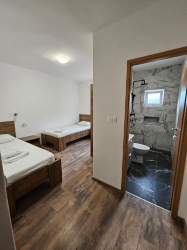 a room with two beds and a bathroom with a toilet at Modern Seaview House Fiore in Starigrad-Paklenica