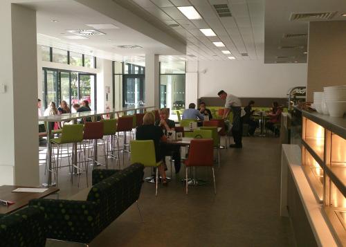 a group of people sitting at tables in a cafeteria at Willow Court in Stirling