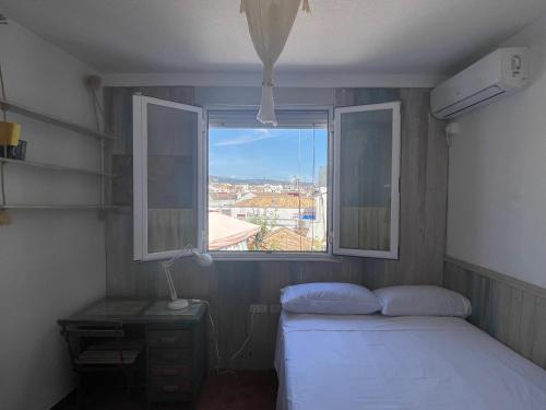 a small bedroom with two beds and a window at Apartamento El Huerto de Orive in Córdoba