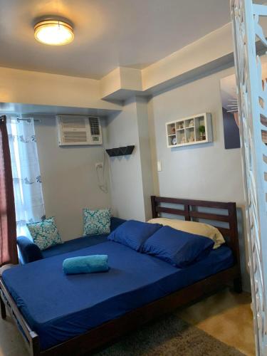 a bedroom with a bed with blue sheets and a ladder at Condo in Avida tower IT park , Lahug Cebu city, Fully furnished in Cebu City