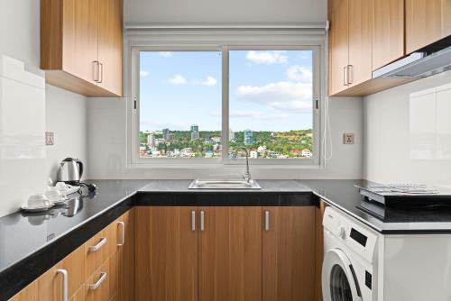 a kitchen with a sink and a window at MLZ Apartments Sihanoukville in Sihanoukville