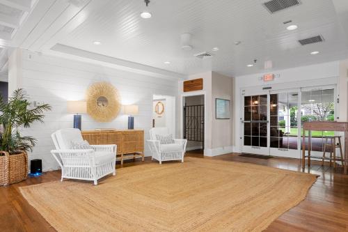 a living room with white chairs and a table at Nantucket Inn in Nantucket