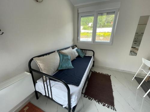 Cama pequeña en habitación con ventana en Villa Tunaj Neu 2023 Novo,New en Bar