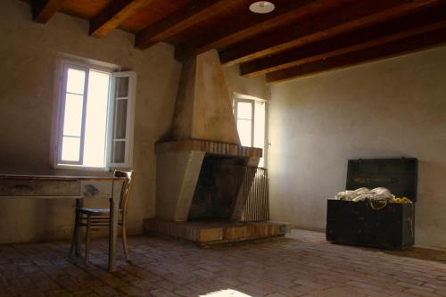 a room with a fireplace and a chair and windows at CASA VACANZE “ LA TERRAZZA “ in Comacchio