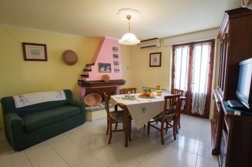 un soggiorno con tavolo e divano verde di Window on the Ogliastra apartment in Baunei a Baunei
