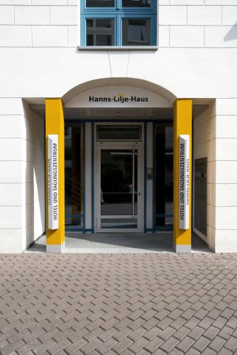 einer Eingangstür eines Gebäudes mit gelben Säulen in der Unterkunft Hanns-Lilje-Haus in Hannover