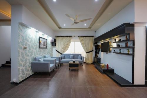 イスラマバードにあるSK Residenceのリビングルーム(青いソファ、テレビ付)