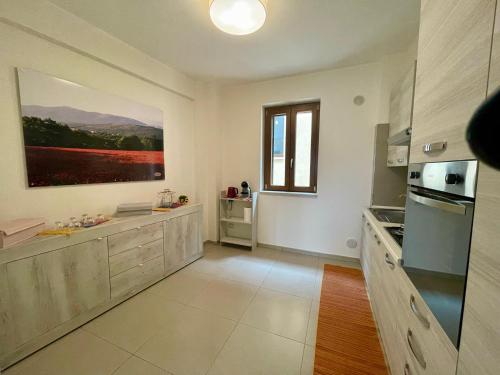 a large kitchen with white walls and a large window at CASANTO' in San Demetrio neʼ Vestini