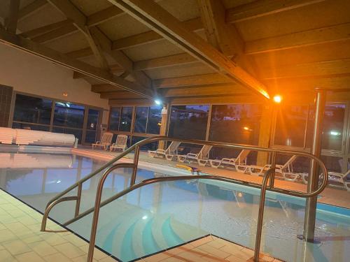 une grande piscine avec une balustrade dans un bâtiment dans l'établissement Village de vacances Fleurs et Neige, à Aussois