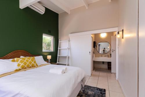 - une chambre avec un lit blanc et un mur vert dans l'établissement San Lameer Villa 3502 by Top Destinations Rentals, à Southbroom