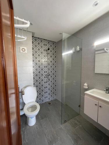 a bathroom with a toilet and a shower and a sink at HOTEL DEL MAR MAZAGAN in El Jadida