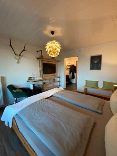 una camera da letto con un grande letto e un lampadario a braccio di Doppelzimmer mit Bad & Balkon a Simmersfeld