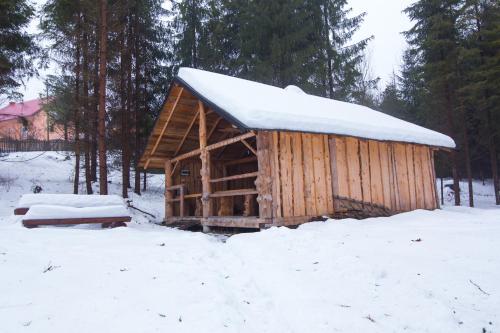 a wooden cabin with snow on top of it at Kolyba w lesie - pole biwakowe - Tokarzonka in Istebna