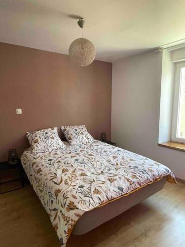 une chambre avec un lit avec une couette dessus dans l'établissement Belle maison de ville rénovée, à Lavardac