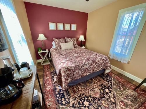 a bedroom with a bed and a red wall at Violet Cottage at Zenzen Gardens in Paonia