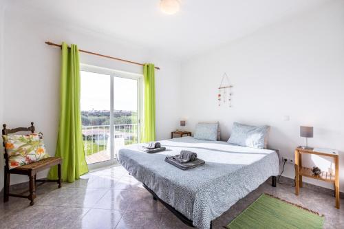 een slaapkamer met een bed en een groot raam bij Local Guesthouse in Sagres