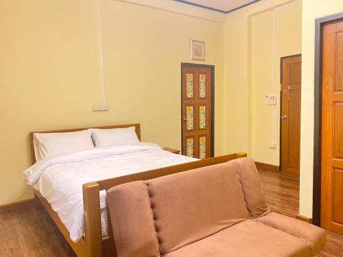 - une chambre avec un lit et une chaise dans l'établissement Dream House Lodge, à Sukhothaï