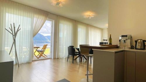 a kitchen and dining room with a view of a balcony at LAKE VIEW APARTMENT in Argegno